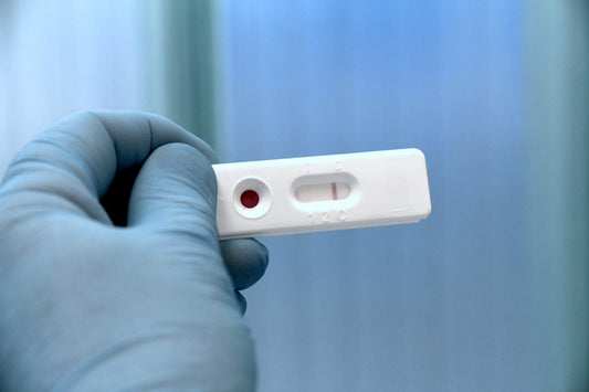 Prostate self-test cassette held in a blue medical gloved hand