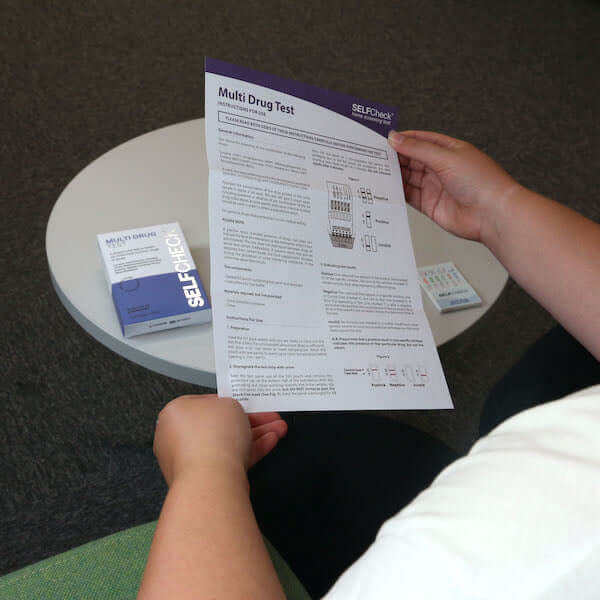 Person reading instructions for SELFCHECK Multi Drug Test