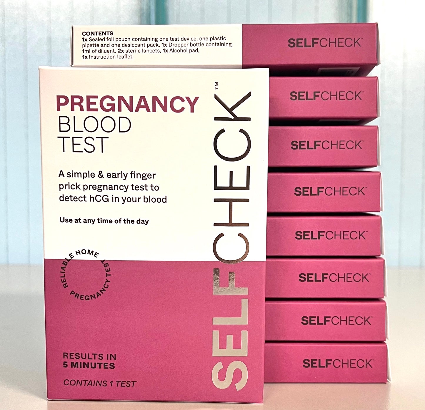 Stack of SELFCHECK Pregnancy Blood Test test kit boxes on lab bench